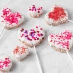 White Chocolate-dipped Rice Krispie Treats | kickassbaker.com #valentinesday #treats #vday #love #ricekrispietreats #ricekrispies #whitechocolate #almondbark #sprinkles #kidstreat #funwithkids #easyrecipes #forkids #nutfree