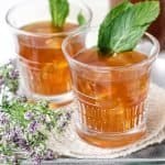 Paleo Sweet Mint Iced Tea on a tray with fresh mint leaves and tea bag in front