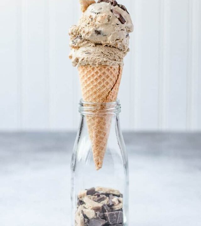 Easy homemade s'mores ice cream in a cone resting in a jar with graham cracker crumbs and chocolate in the bottom of the jar