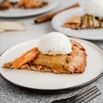 slice of maple apple galette on a plate with scoop of vanilla ice cream on top