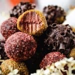 Bowl of pumpkin truffles with a bite taken out of one on top
