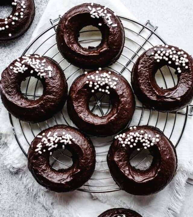 Overhead of plant-based chocolate donuts on a round cooling rack