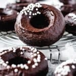close-up of a plant-based chocolate fudge donut with white sprinkles