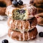 stack of 3 blueberry cake donuts, top donut with bite taken out