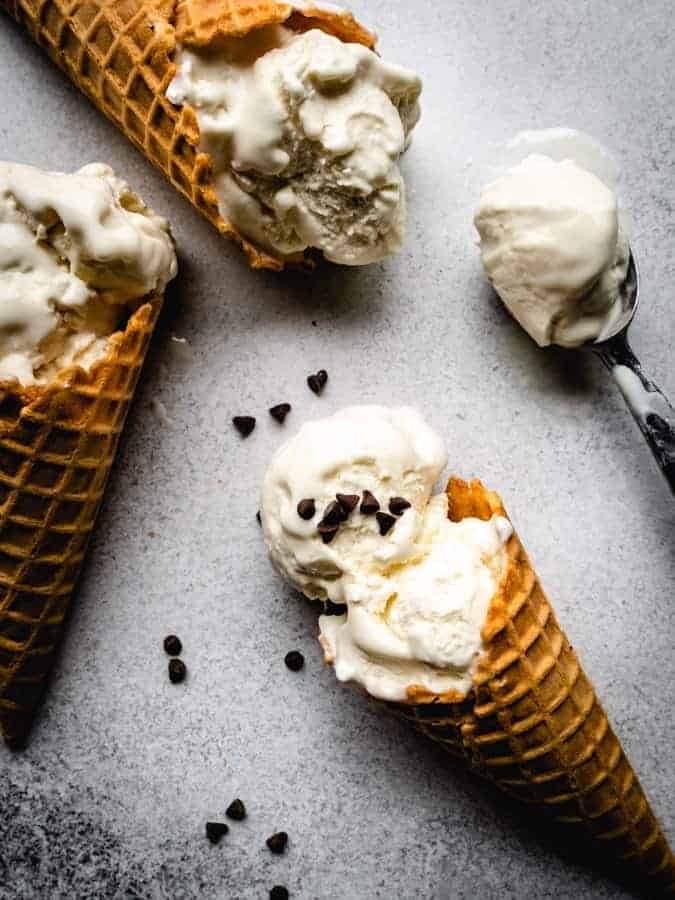 vanilla ice cream cones on a backdrop with mini chocolate chips