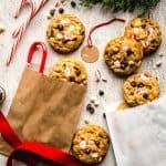holiday decorations surrounding white chocolate peppermint chocolate chip cookies