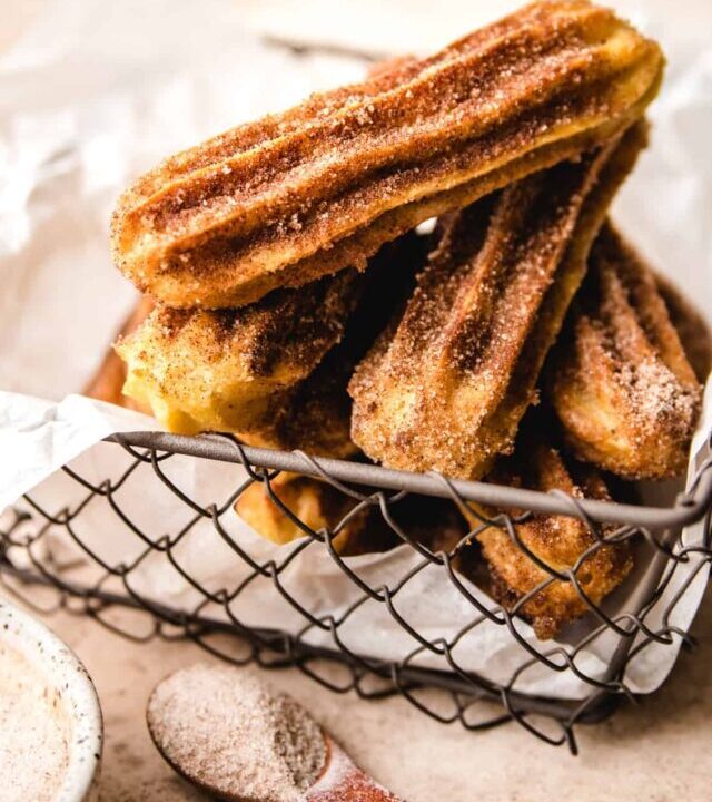 mesh basket with parchment paper lining with stack of churros