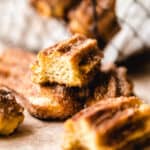 churro close up with a bite missing and mesh basket in the background