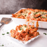 Cheese pull coming off the spatula as the baked ziti is plated.