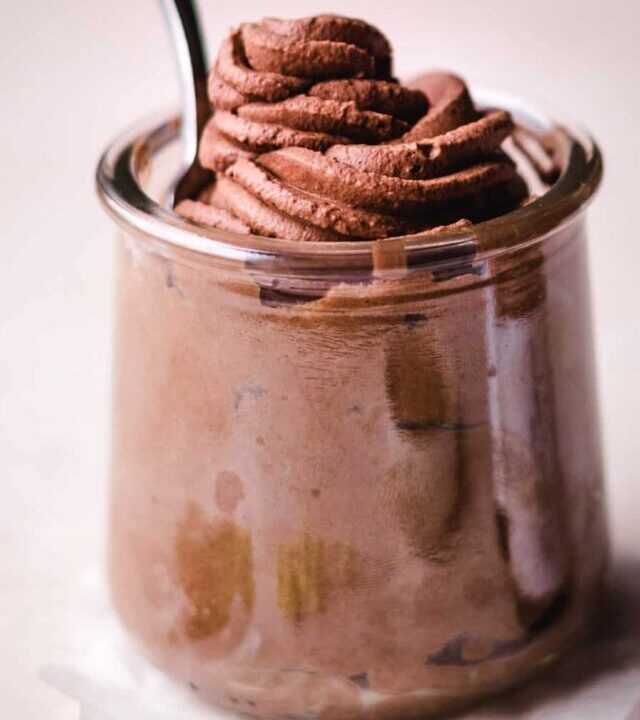 Dark Chocolate Mousse in a clear jar with a spoon.