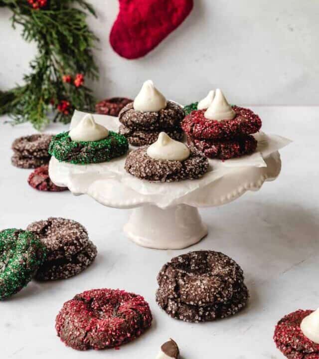 Festive chocolate thumbprint cookies filled with peppermint schnapps filling on a cake stand.