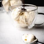 Pouring chocolate sauce onto eggless ice cream in a mug.