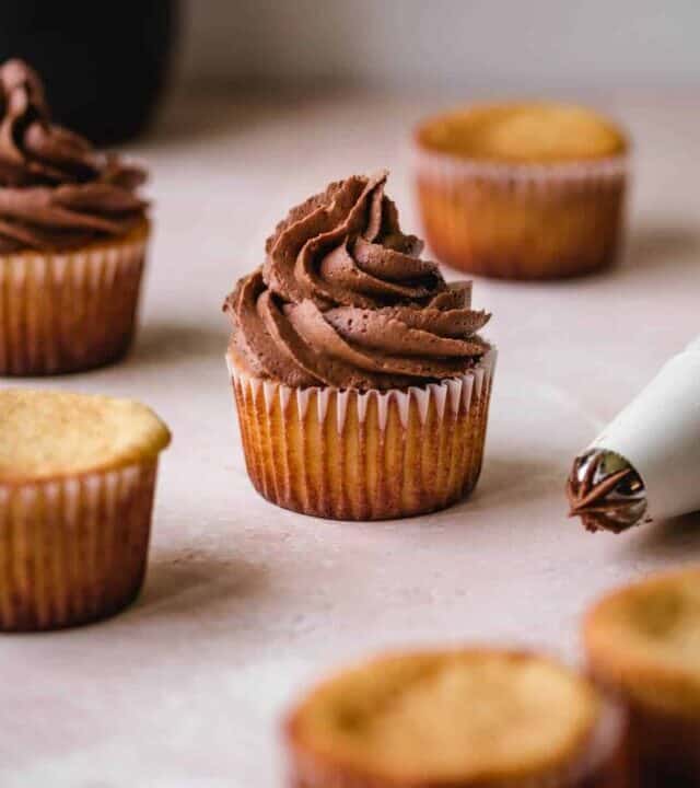 Cupcakes with and without dark chocolate buttercream frosting.
