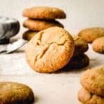 A brown butter cookie leaning against a stack of cookies.