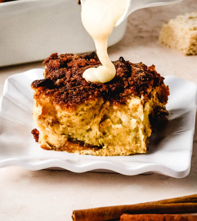 Bourbon sauce being poured over a slice of bread pudding.