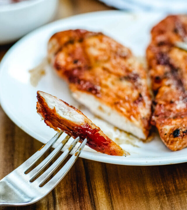 Bite of chicken with sweet and spicy bbq sauce covering it.