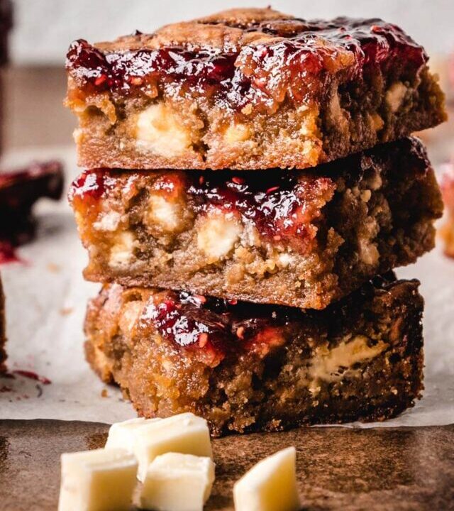 Stack of 3 white chocolate and raspberry blondies.