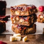 Stack of 3 white chocolate and raspberry blondies.