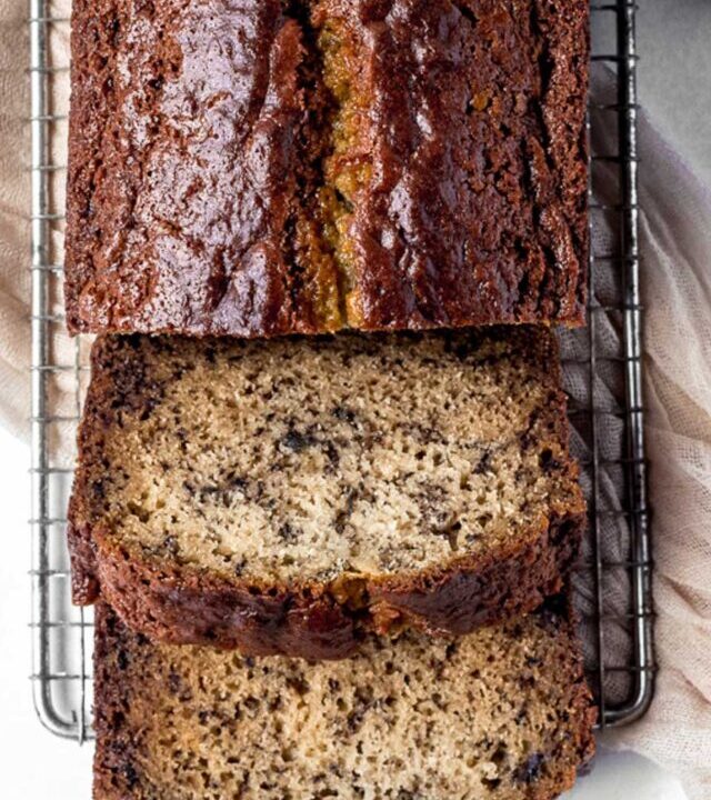 Sour cream banana bread sliced and served on a cooling rack.