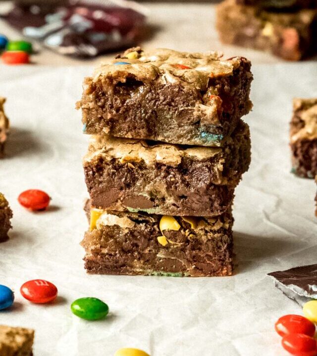 Stack of M&M cookie bars with M&Ms scattered around.