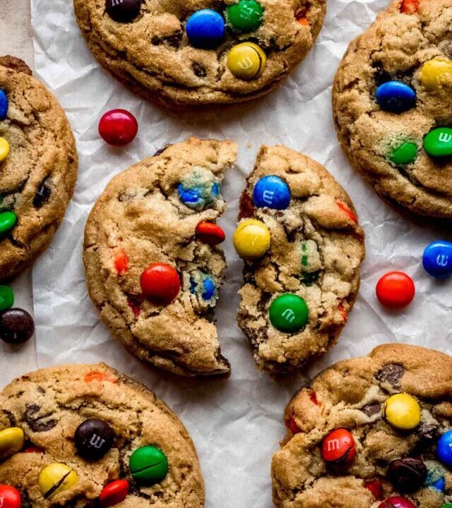 A just baked M&M cookie broken in half to show the chocolate melted.