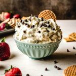 Light and fluffy cream cheese dip in a bowl with strawberries and crackers.