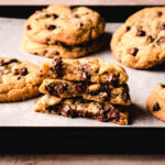 Stack of chocolate chip cookies without brown sugar cut in half with melty chocolate chips.