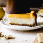A slice of lemon cheesecake with lemon curd on a plate.