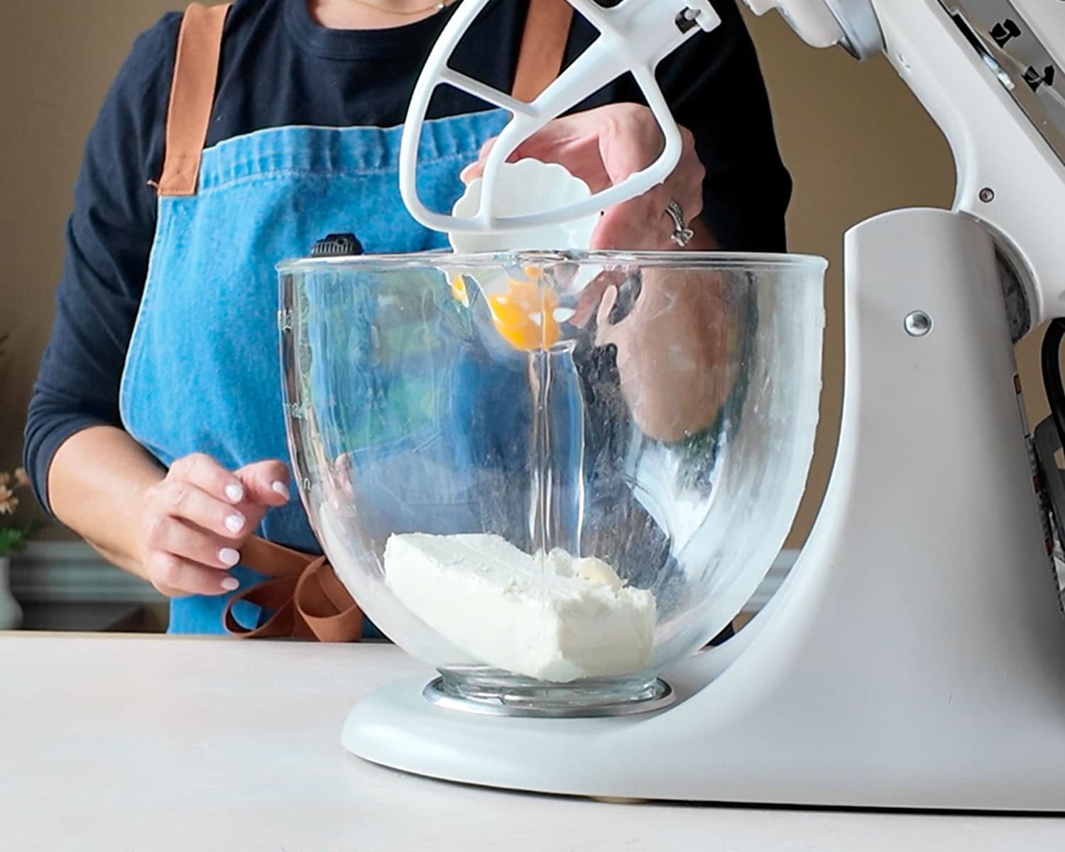 Add room temperature egg to the mixing bowl with the cream cheese.