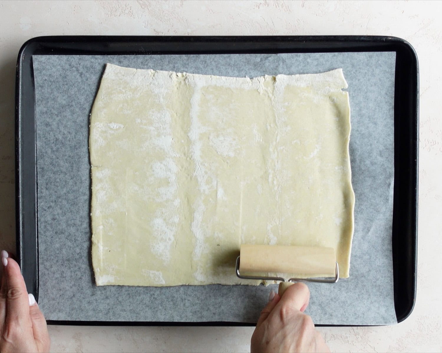 Use a rolling pin to flatten the puff pastry into a larger rectangle.